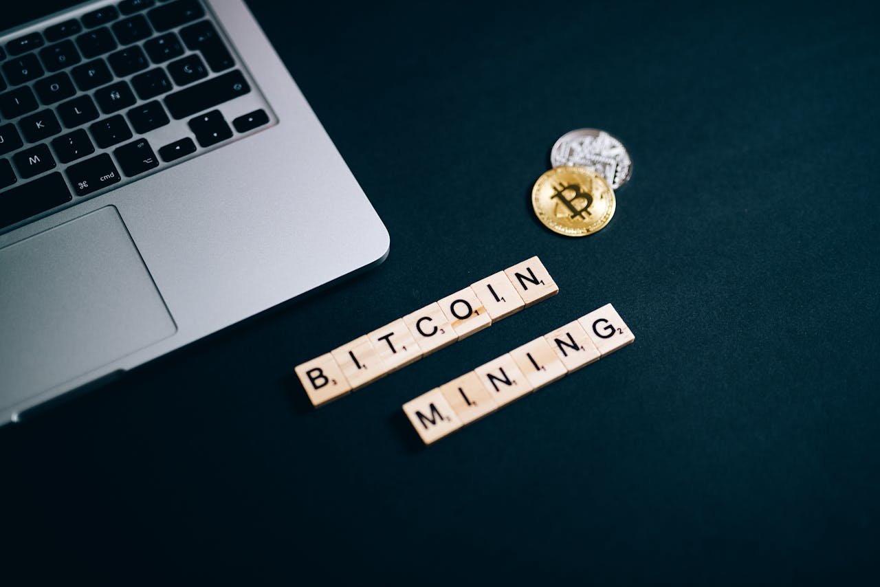 Top view of Bitcoin mining concept represented with laptop keyboard and Scrabble tiles.